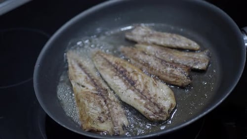 Fish Fillets Frying in Oil on Stove