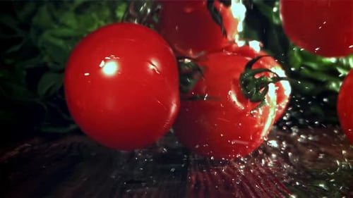 Tomates fraîches avec un jet d'eau filmées par une caméra haute vitesse à 1000 images par seconde