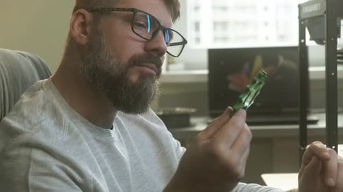 Male Engineer with Laptop Inspecting 3d Printed Object in Modern Start Up Office