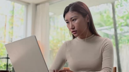 Female Solopreneur Analyzing Data on Laptop