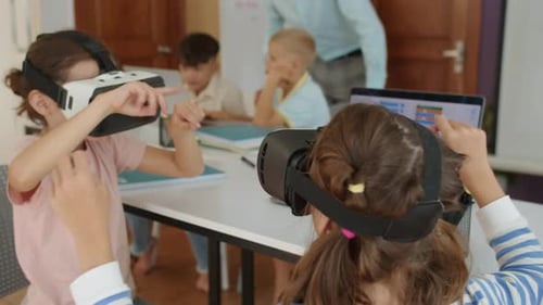 Girls Using VR Glasses during Group Computer Class at School