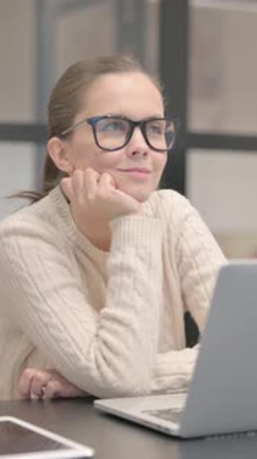 Pensive Young Woman Sitting in Office