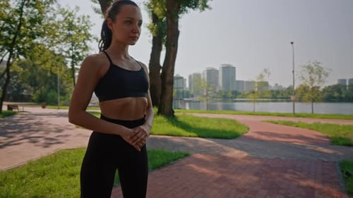 Woman Stretching in Urban Park on Sunny Day