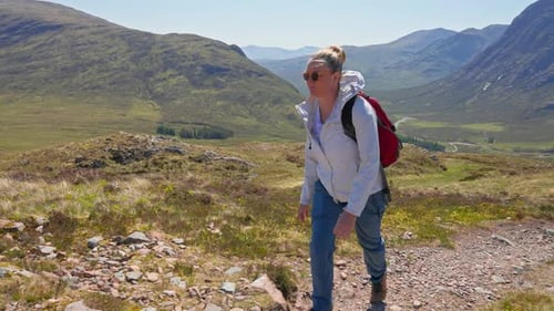 Profile view of backpacker hiking on Devil's Staircase mountain trail with dramatic highland view