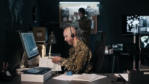 Serious Men Analyze Military Data in Dark Office