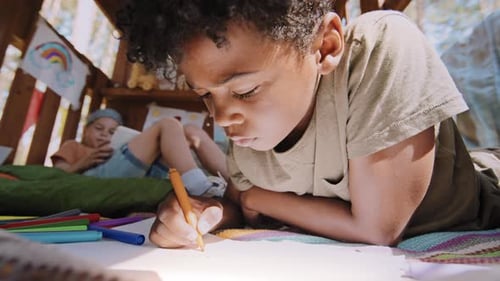 Children Drawing Together in a Cozy Playhouse