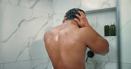 Man Rinsing Shampoo in Modern Marble Shower