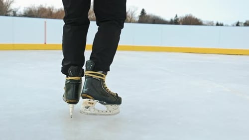 White ice on river lake in park. Legs of man in skates on ice.
