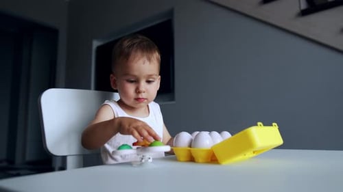 Happy Child Playing with Eggs and Spinner Toy