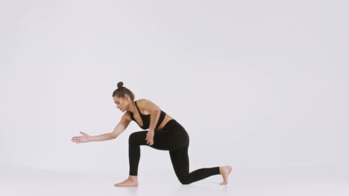 Frau praktiziert Yoga-Posen für Flexibilität und Stärke in einem hellen Studio