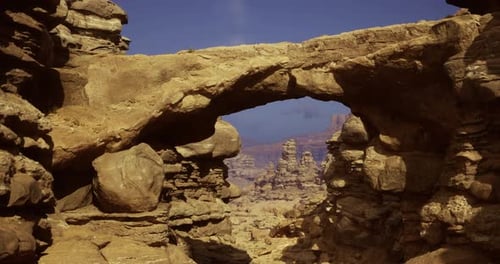 Natural Rock Arch Formation in a Sunny Desert Landscape with Distant Mountains