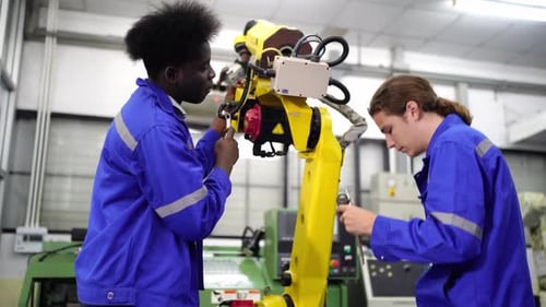 Engenheiros inspecionando e verificando a máquina automatizada de robôs de soldagem de máquinas de armas na fábrica.