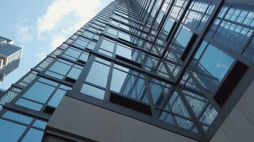 New York skyscraper, tilting upwards to a low-angle perspective of the building against a blue cloud