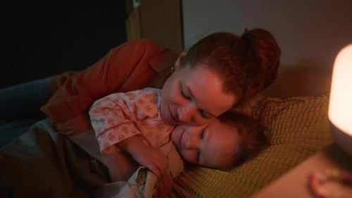 Mother Hugs Child in Bed at Night