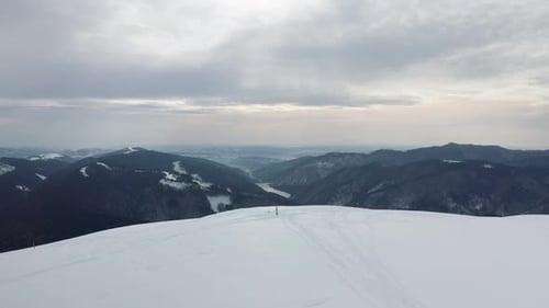 Figure solitaire sur le pic Gainatu avec le barrage de Rausor en arrière-plan, montagnes Iezer-Papusa, Arges, Roumanie