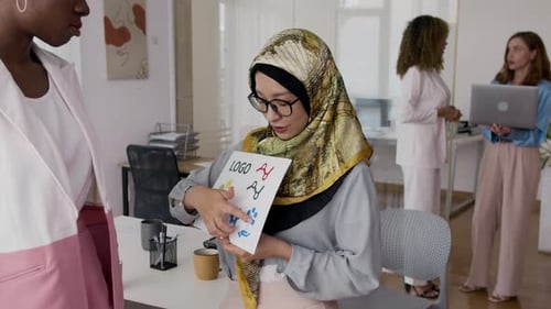 Women Discussing Logo Design in Modern Office