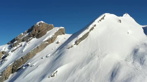 Luftaufnahme einer rechten nach linken Seite schneebedeckter Berggipfel in den französischen Alpen im Winter mit