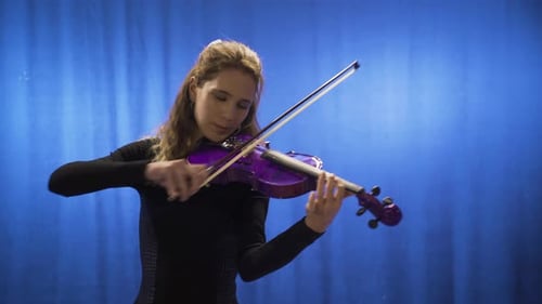Young Woman Plays Purple Violin on Blue Backdrop