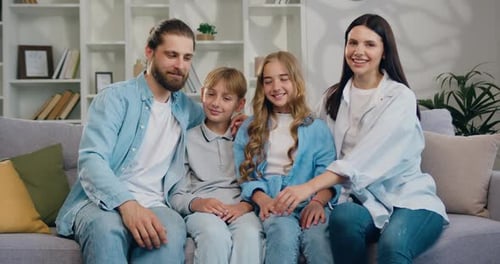 Happy Family Smiling Together on Gray Sofa