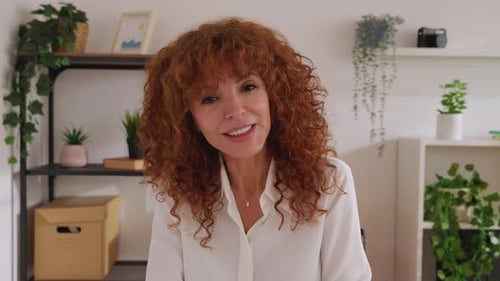 Woman with Curly Hair Smiles and Speaks Indoors