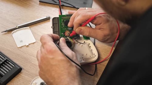 Technician Repairing Electronic Circuit With Multimeter
