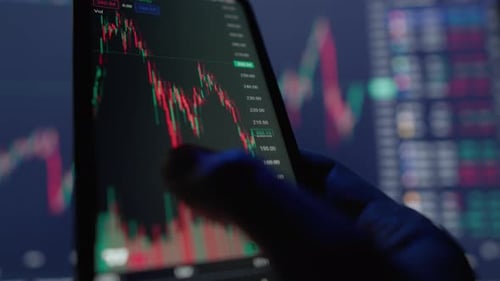 The Investor Analyzes Trading Data and Charts on His Smartphone to Make Smart Financial Movements