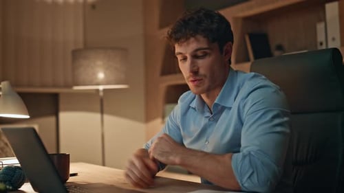 Young Adult Video Conferencing and Reviewing Documents at Home