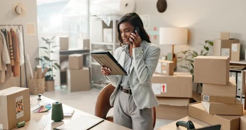 Woman Talks on Phone Holding Tablet in Office