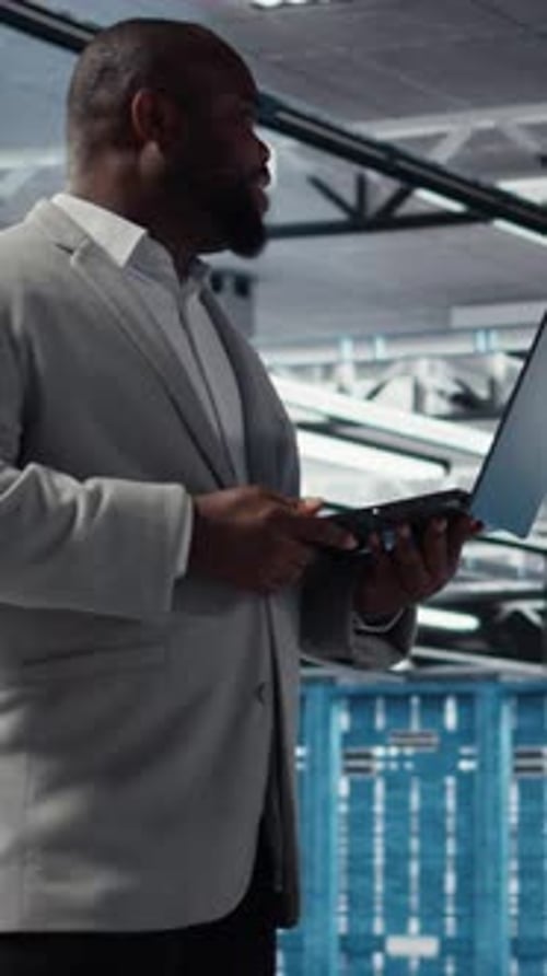 Vertical Video Admin Walking in Data Center Industrial Platform Analyzing Performance