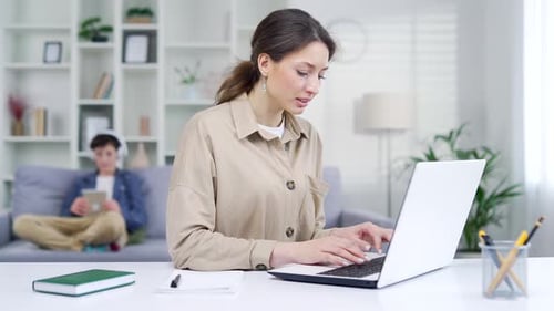 young woman mother with child works remotely at home. A female freelancer entrepreneur works