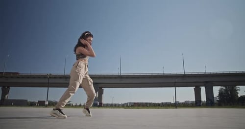 Young Woman Rehearsing Modern Dance Near Bridge