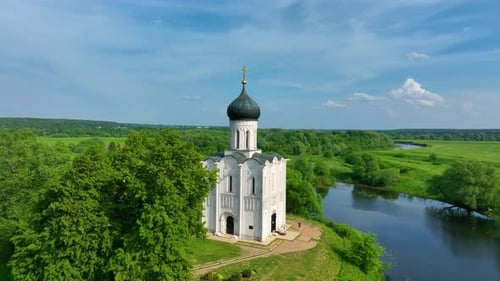 Aerial view of a historic church by a tranquil river