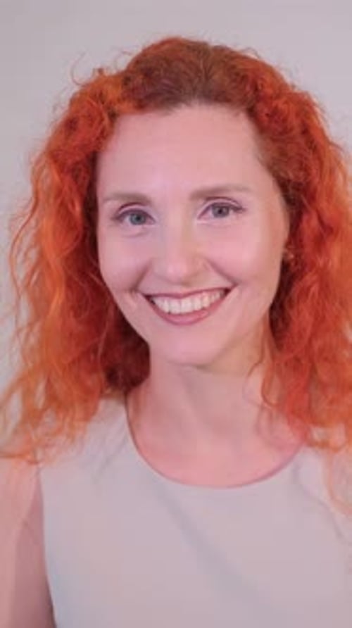 Une joyeuse femme rousse s'engage de manière ludique avec la caméra, dégageant du charisme