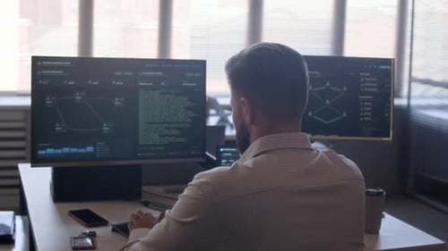 System Administrator Monitoring Network Activity on Computer in Office