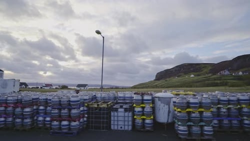 Barriles de
cerveza frente a una fábrica de cerveza en Escocia. Barriles de cerveza listos para el transporte. Filmado en la isla de