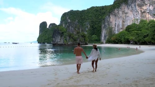 Couple Strolls Hand in Hand Along the Pristine Beach of Koh Hong Islands in Thailand
