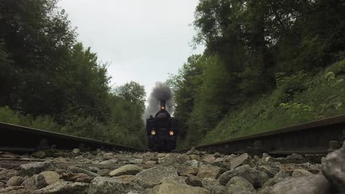Historical Steam Engine Train Locomotive Driving on Railroad Tracks