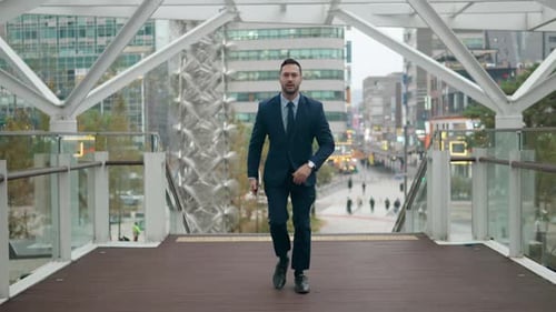 Businessman Running Across City Bridge Holding Tablet