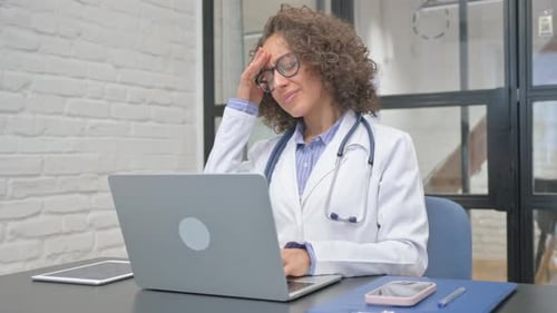 Hispanic Female Doctor having Headache in Clinic