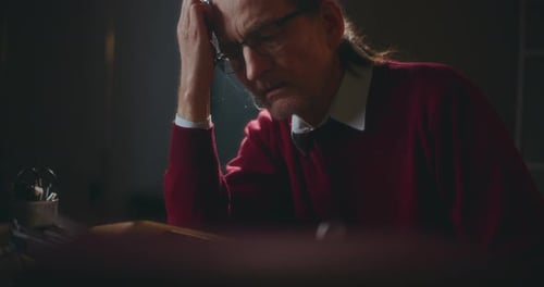 Man Sitting at a Desk with His Head in Hand