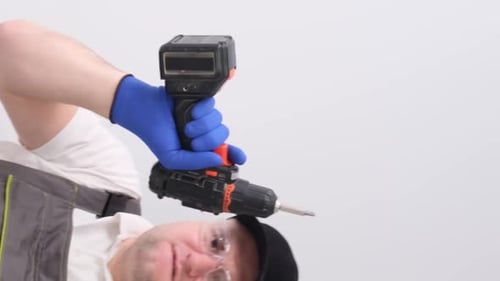 Man Holding Drill Wearing Safety Glasses and Gloves