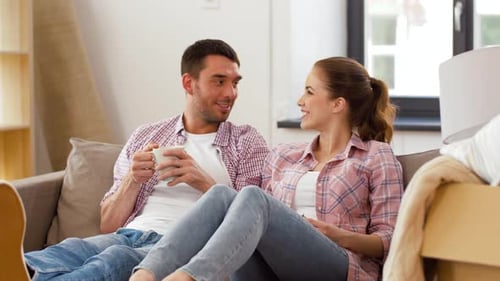Moving, People, Repair and Real Estate Concept - Happy Couple Sitting On