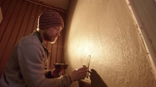 Man Spreads Plaster on Wall with Trowel