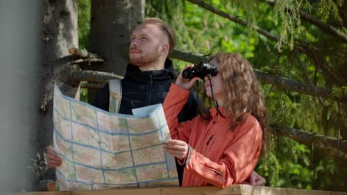 Couple Using Map and Binoculars in Nature