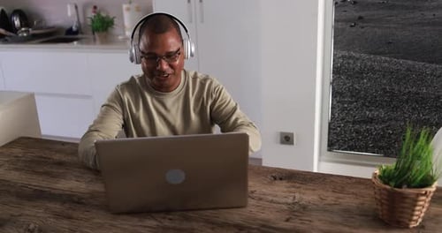 Smiling Man Working on Laptop at Kitchen Table
