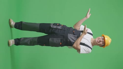 Asian Man Worker Wearing Goggles And Safety Helmet Smiling And Pointing To Side In The Green Screen