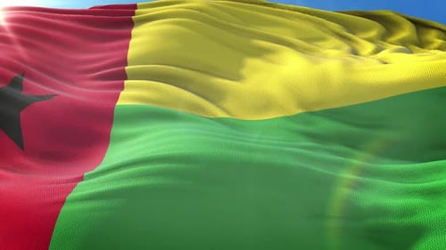 Waving Guinea-Bissau National Flag Against Blue Sky