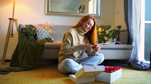 Woman Examining Christmas Decorations in Home Setting