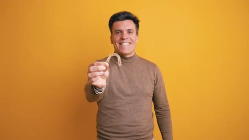 Middle Aged Man Holding Invisible Dental Aligner for Teeth Straightening