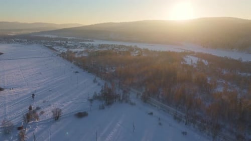 Aerial View of Snow-Covered Rural Landscape at Sunset